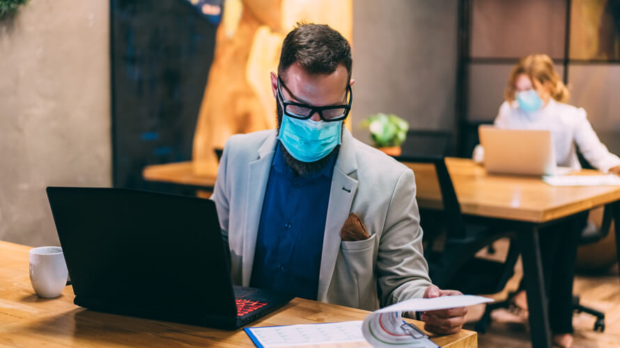 Seorang pria menggunakan masker saat bekerja